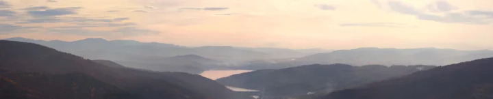 暮色天空下，层叠群山环绕着宁静的湖泊。