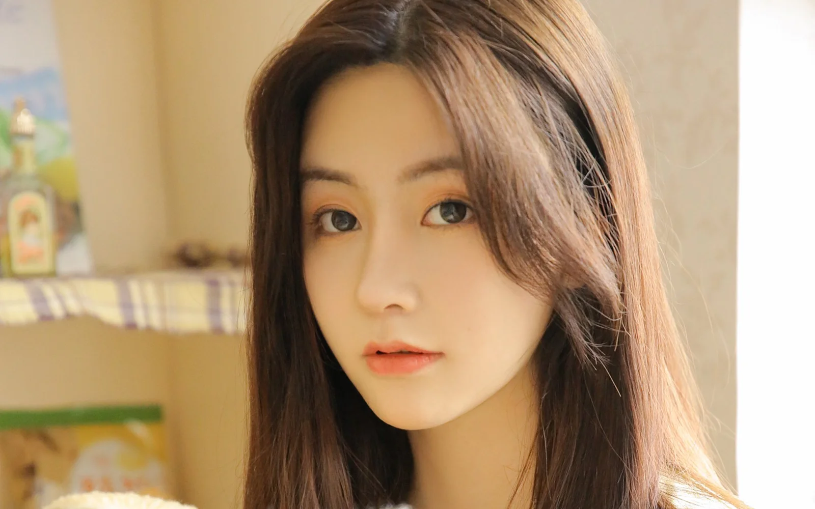 一位长发女性在室内暖色光线下看向镜头。