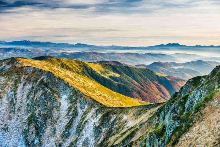 金色山脊延伸向层叠群山与云雾缭绕的远方。