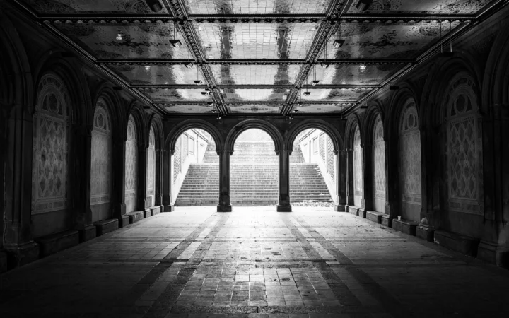黑白画面展现一座带有拱门、阶梯和铺砖地面的古典大厅。