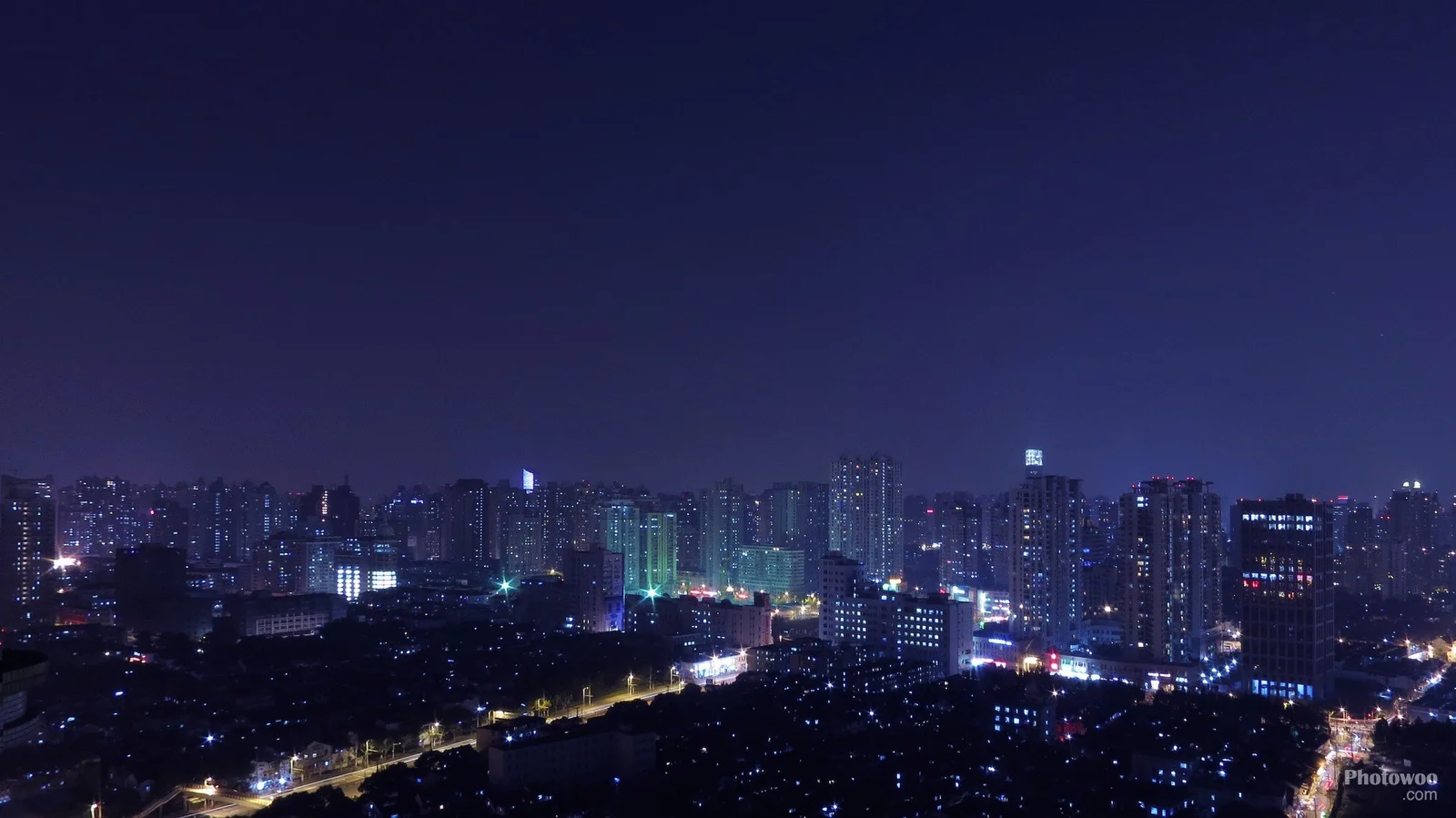 夜色中的城市天際線被高樓燈光與道路燈火點亮。
