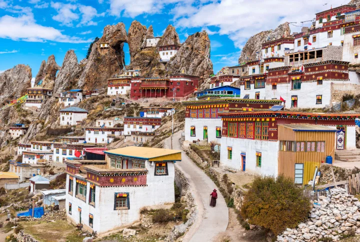 群山环抱的山坡上坐落着色彩鲜艳的藏式寺院和村落建筑。