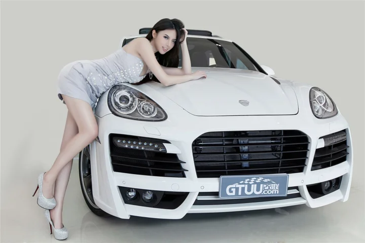 一名成年女性倚靠在白色跑车旁，车辆占据画面主体。