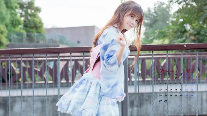 一名年轻女子站在户外桥边，身穿浅色服装，背景是树木和栏杆。