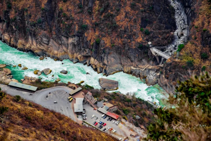 俯瞰秋色峡谷中的碧绿激流、岩壁、林木和山脚停车区。