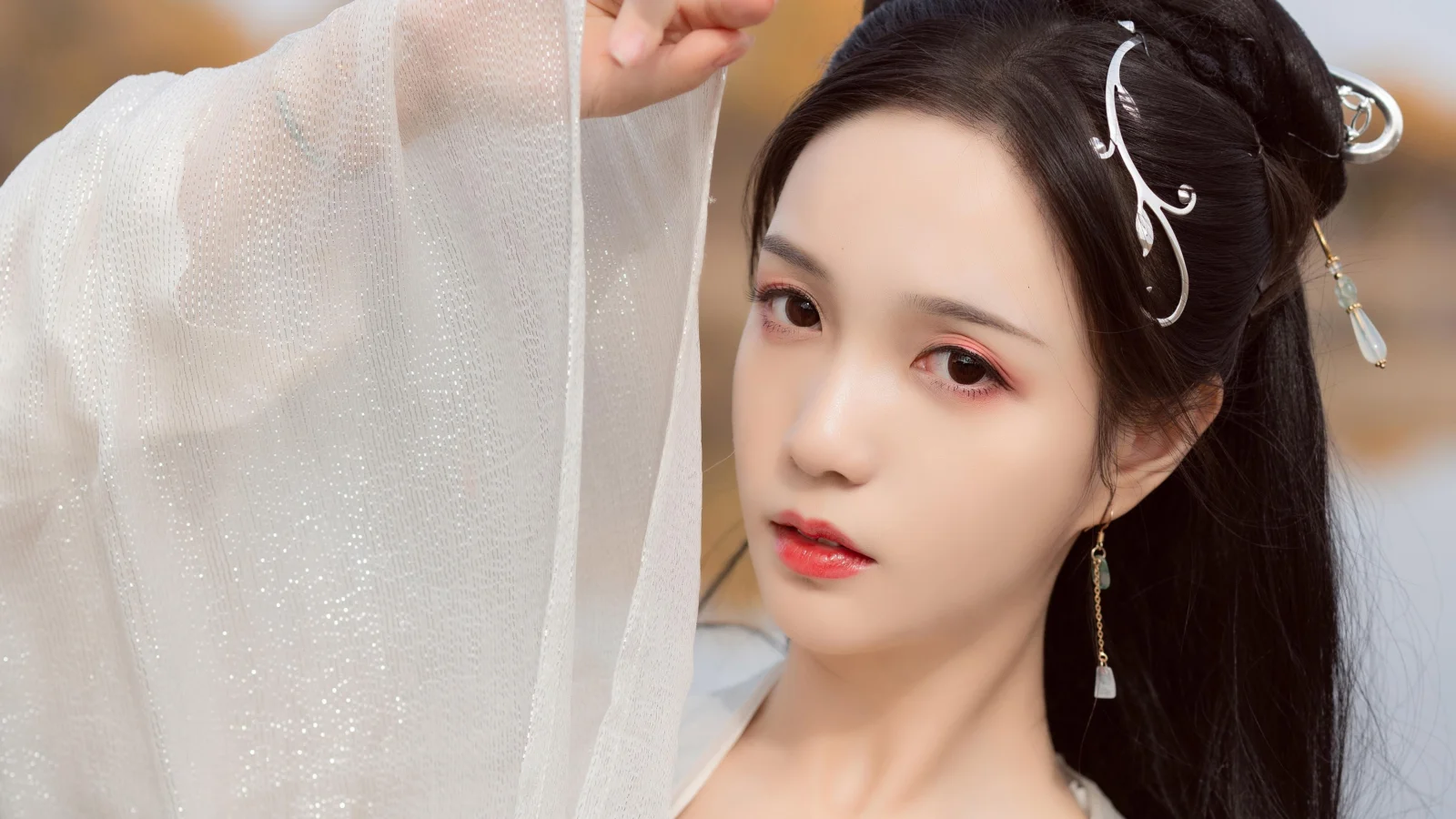 一位佩戴发饰、身着白色传统服饰的女子近距离人像。
