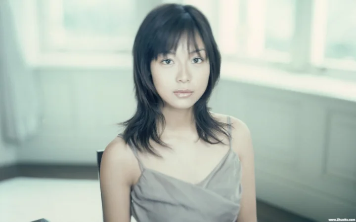 一名成年女性坐在室内明亮柔和的光线中，面向镜头呈现自然肖像。