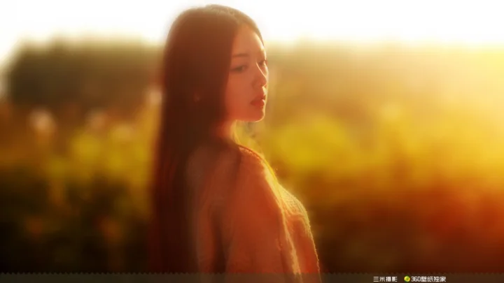 一名女子在金色夕阳和朦胧户外背景前的侧脸画面。