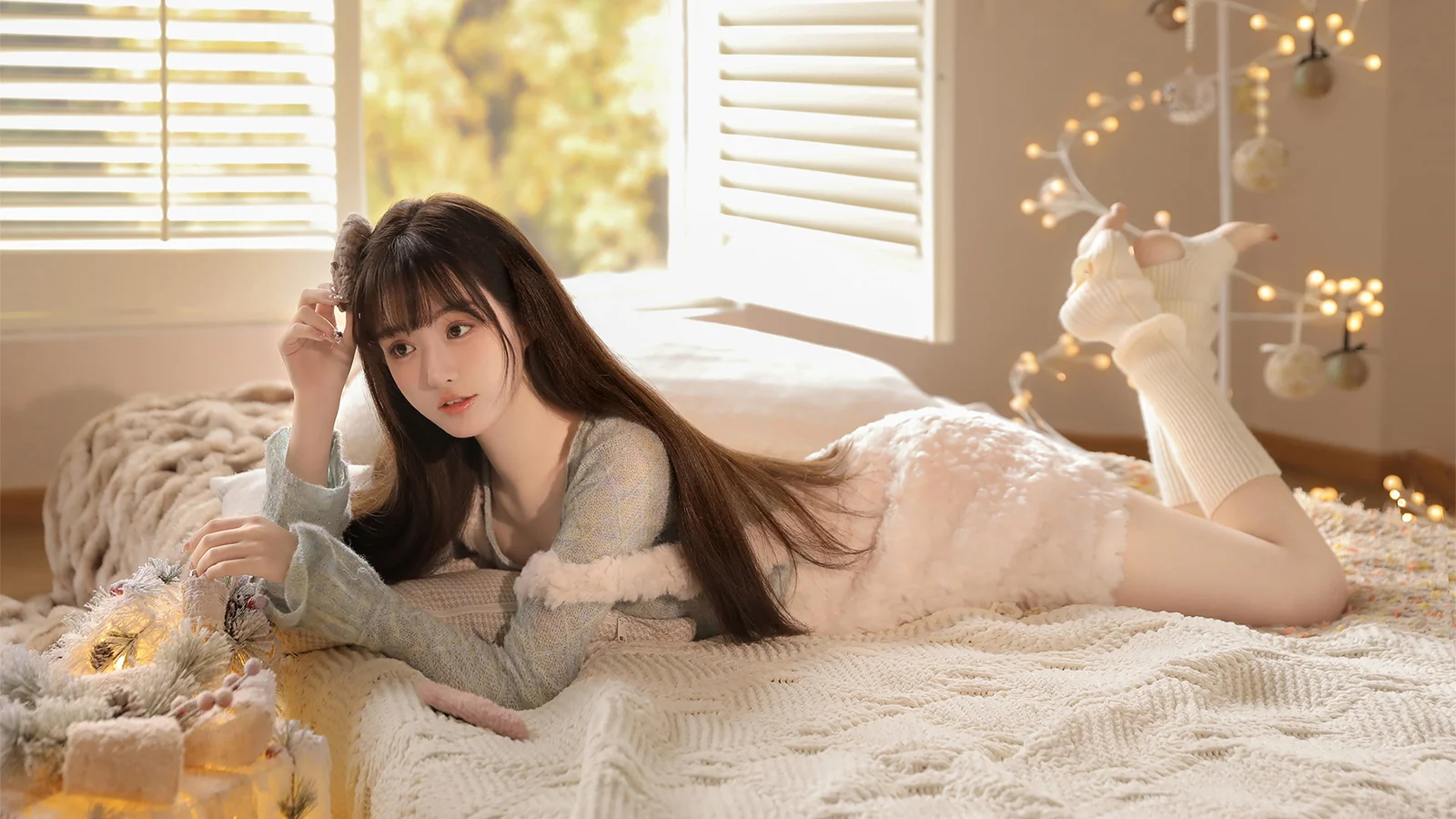 長い髪の女性が、暖かく明るい寝室のベッドに横たわっている。