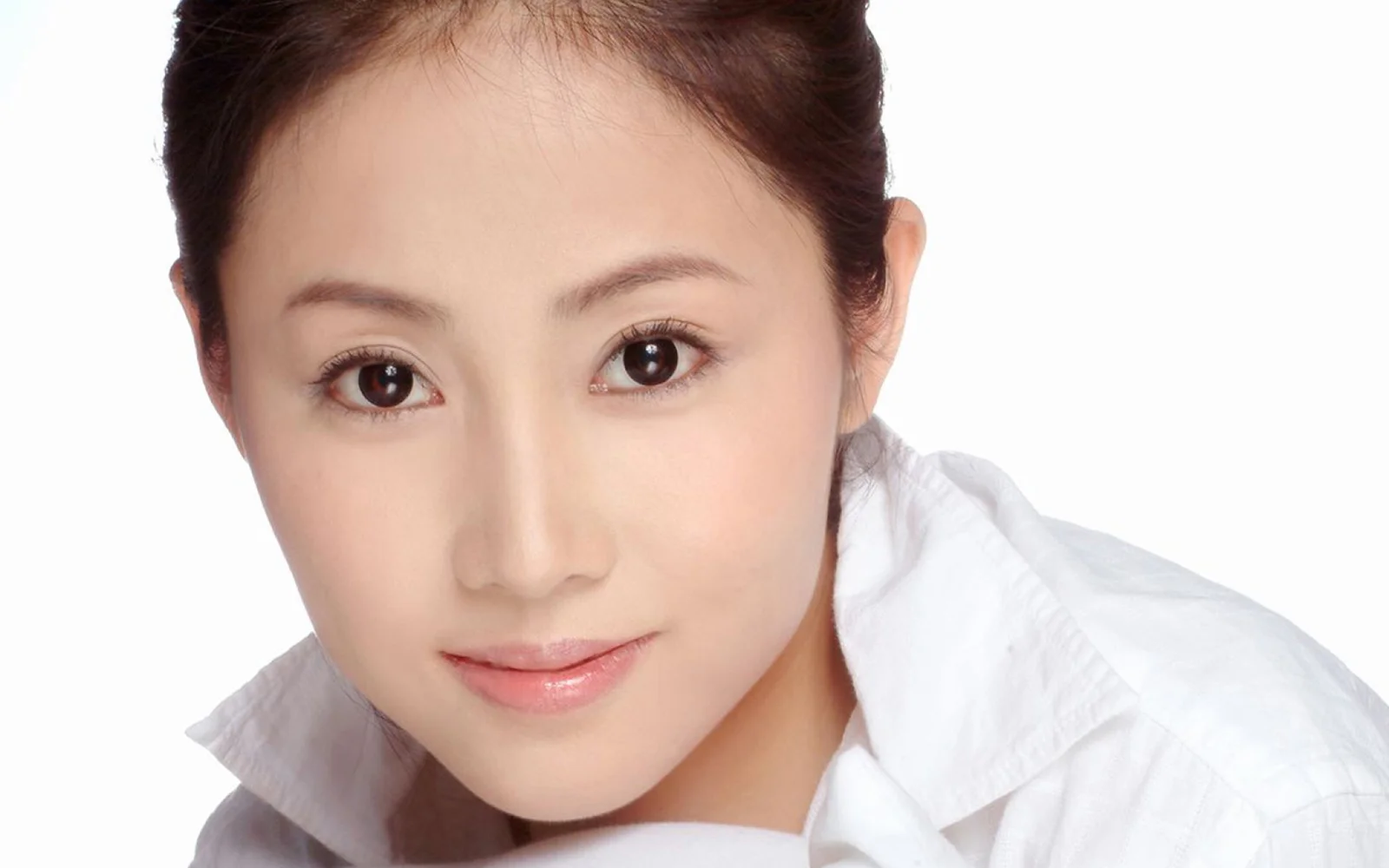 흰색 칼라 셔츠를 입은 성인 여성을 흰색 배경에서 촬영한 클로즈업 인물 사진입니다.