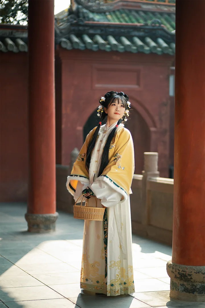 一名身穿传统服饰的女子站在红色柱廊与古建筑之间。