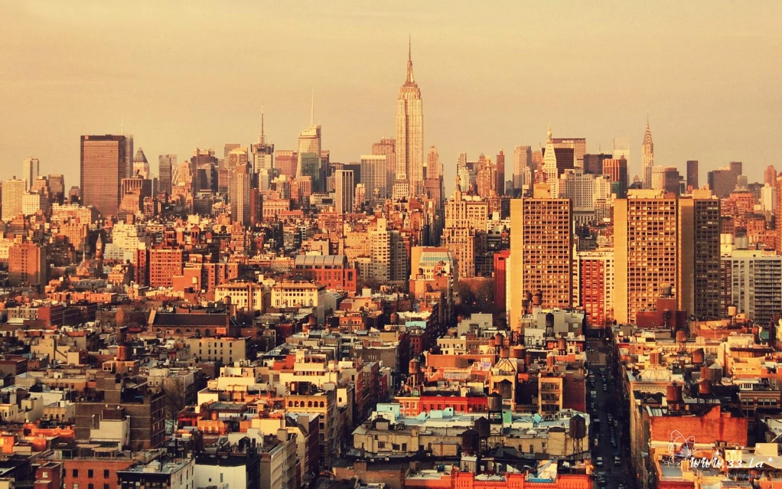暖色调的纽约城市天际线中，高楼建筑密集分布，中央可见帝国大厦。
