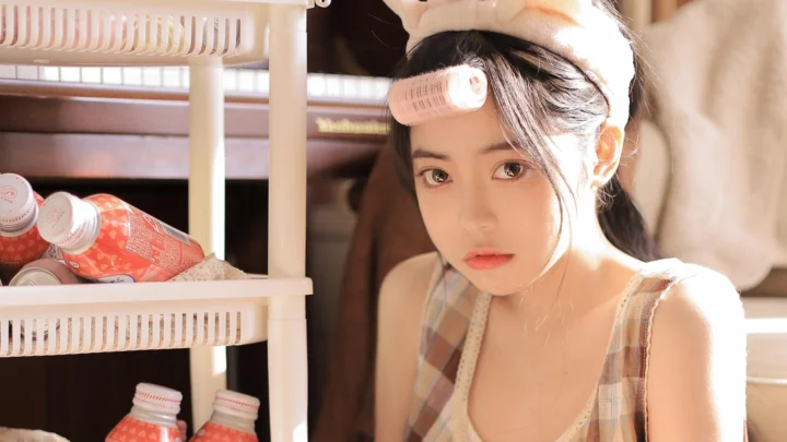 一名女性在室内暖色阳光下靠近置物架，面向镜头。