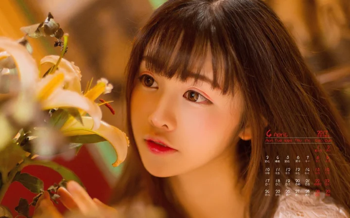 一位女性在暖色光线下靠近百合花凝视镜头。