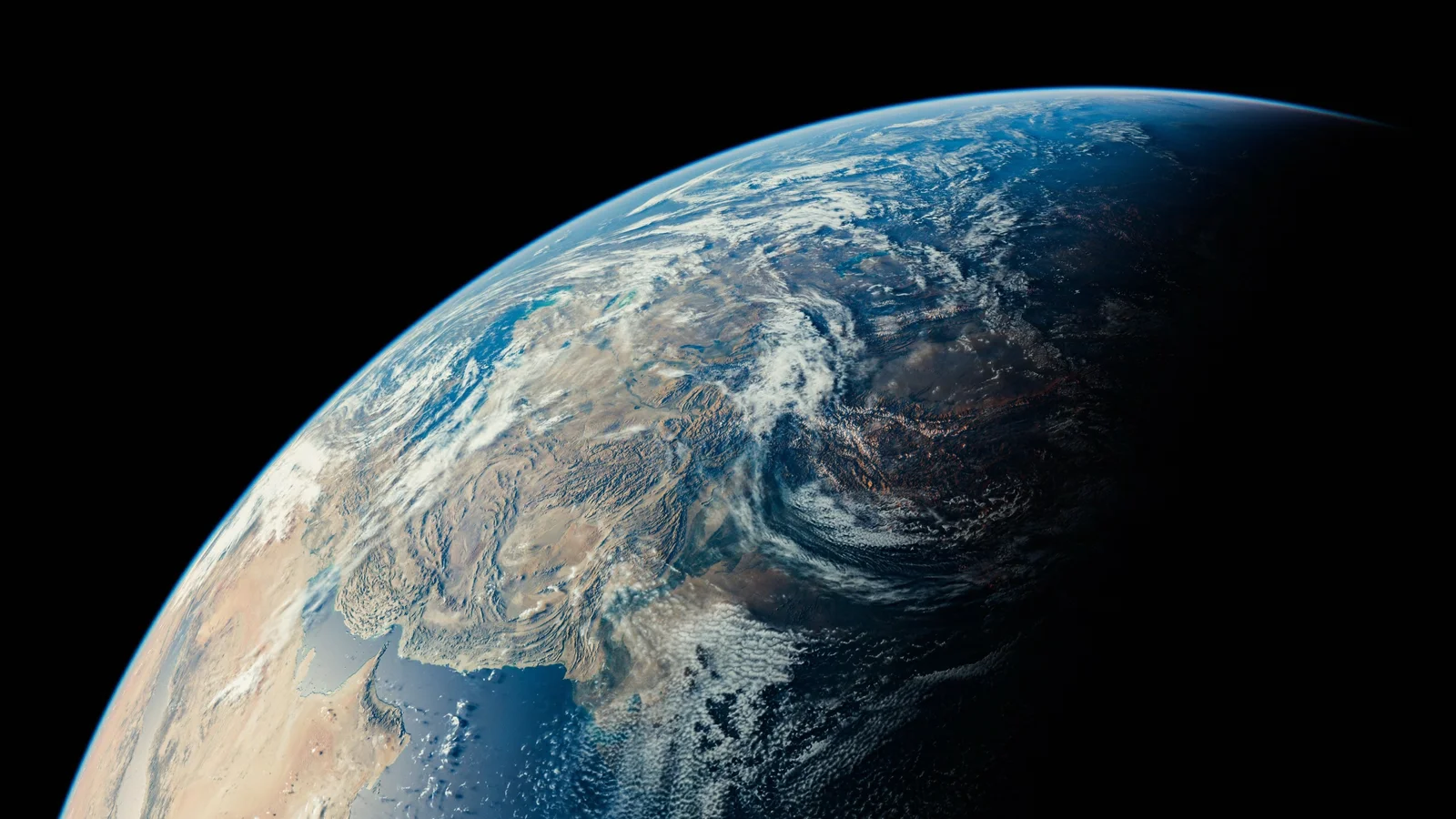 黒い宇宙を背景に、雲と海に覆われた地球を宇宙から見下ろしています。