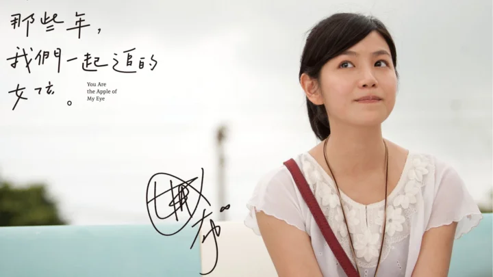 一名身穿白色上衣的女子位于画面右侧，左侧是手写文字和签名。