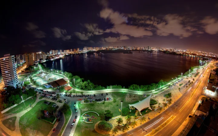 夜色中的城市水岸全景，灯光沿着街道、建筑和水面展开。