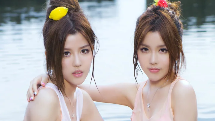 两名女性在水边面对镜头拍摄肖像。