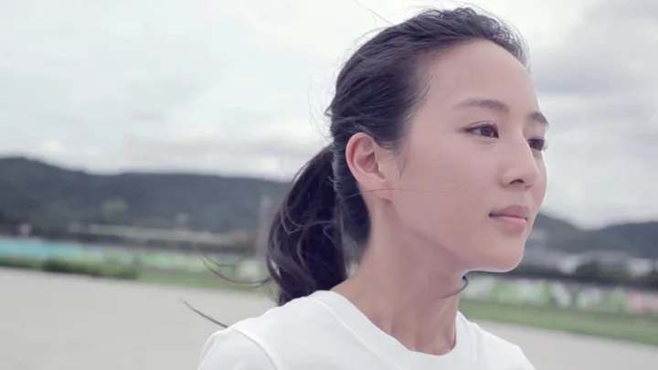 一名扎着马尾的女性在户外背景前的侧面近距离肖像。