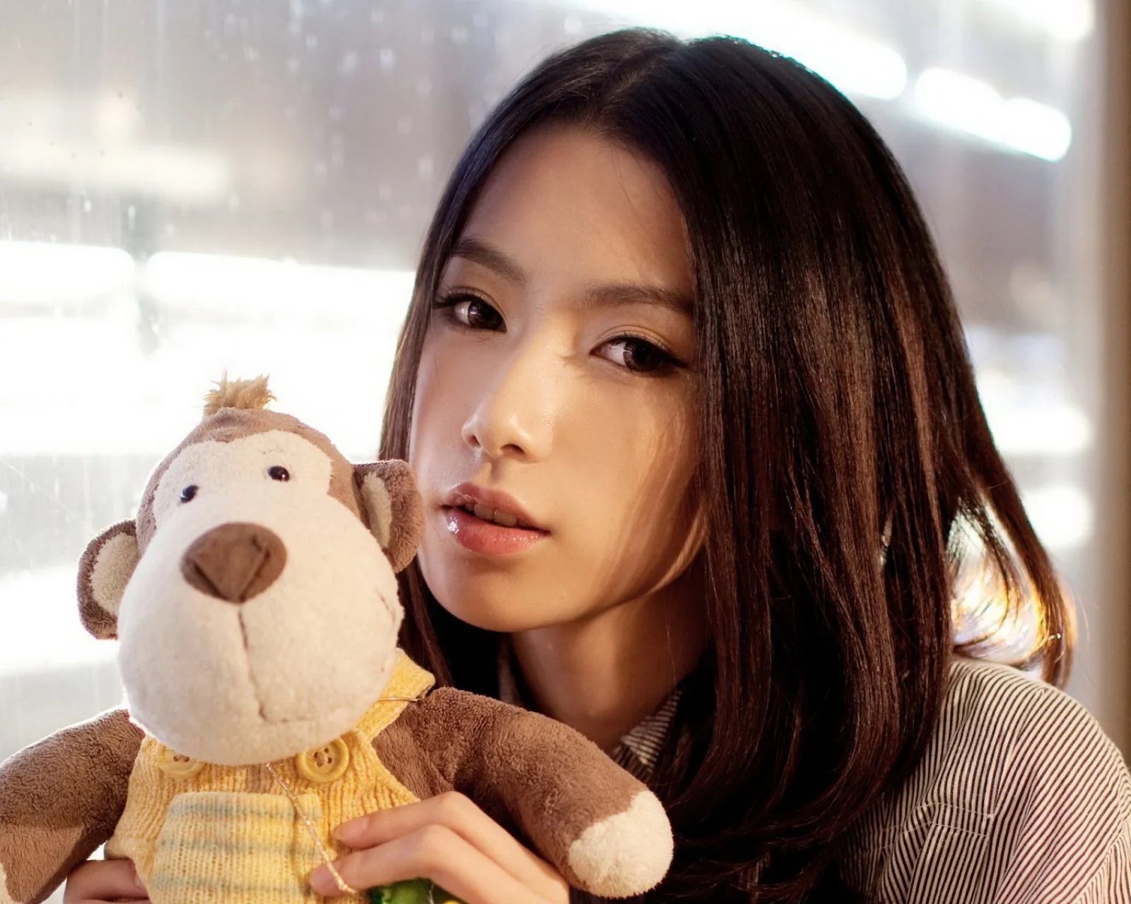 여성이 봉제인형을 안고 카메라를 바라보는 실내 클로즈업 인물 사진입니다.