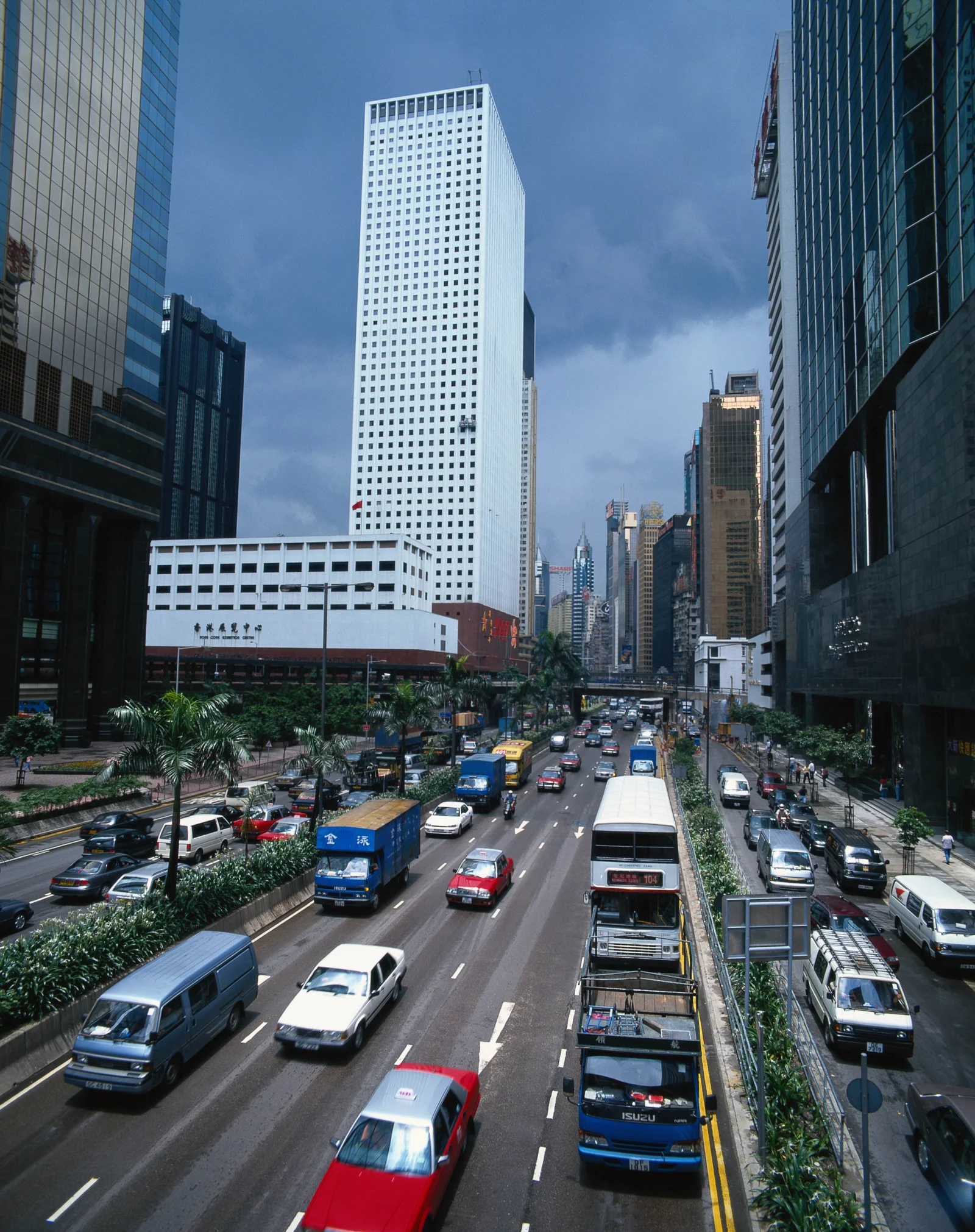高楼林立的城市街道上车流繁忙，蓝天映衬着现代建筑。