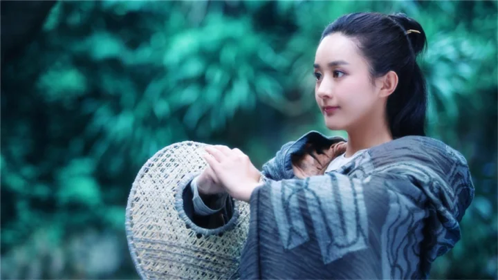 一名女子在绿色森林背景前双手扶着一个圆形编织篮。