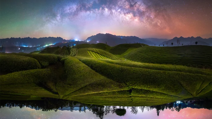 夜空中的银河映照着起伏的茶园、远山与水面倒影。