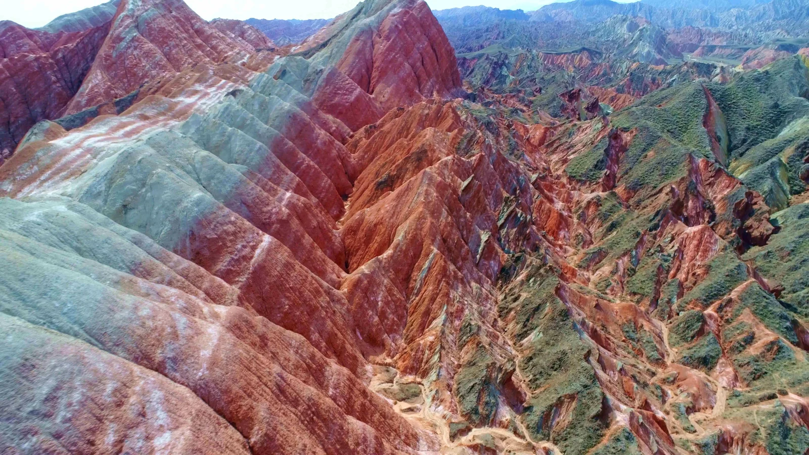 画面展示了层叠起伏、色彩斑斓的山脉与岩石山脊。