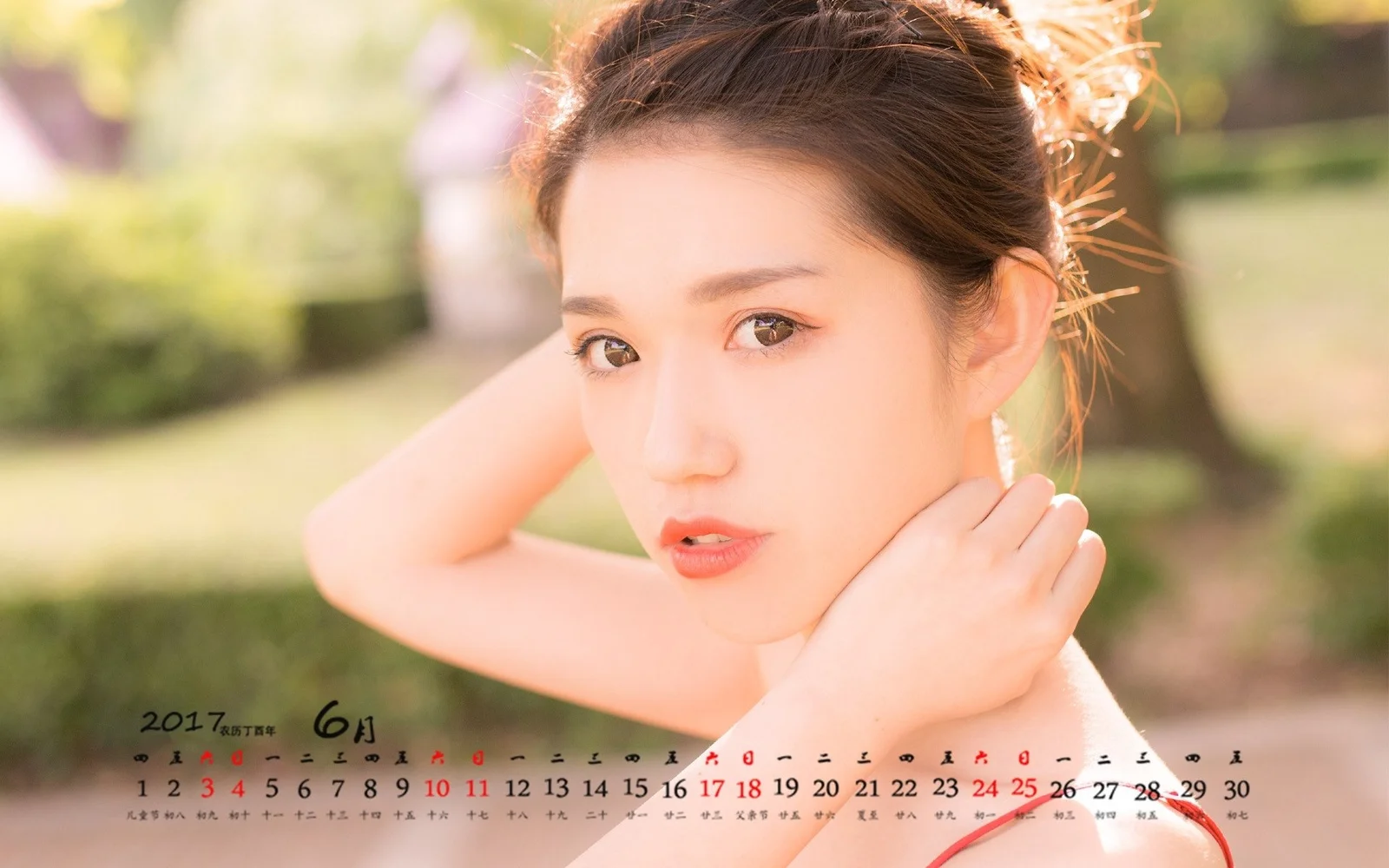 一位成年女性在户外阳光下看向镜头，画面下方叠加了日历。