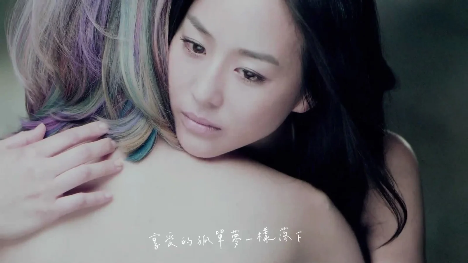 画面展示两名女性的近距离肖像，其中一人留着黑发，另一人的彩色发丝位于左侧。