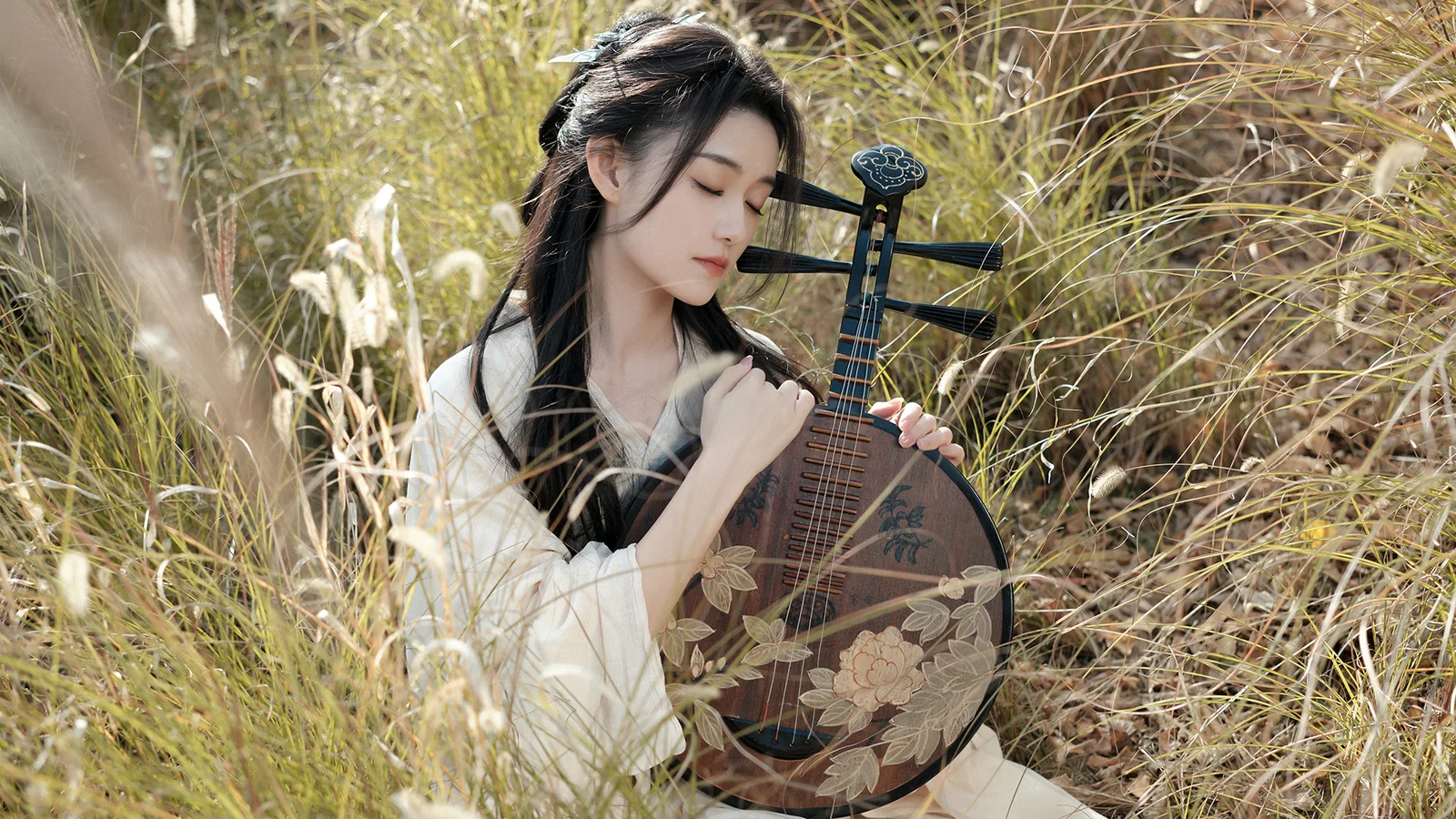 女性が背の高い草むらで花模様の琵琶を抱えている。