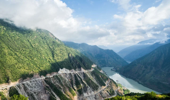 云雾笼罩的群山、峡谷湖泊与沿山而行的公路构成壮阔的自然风景。