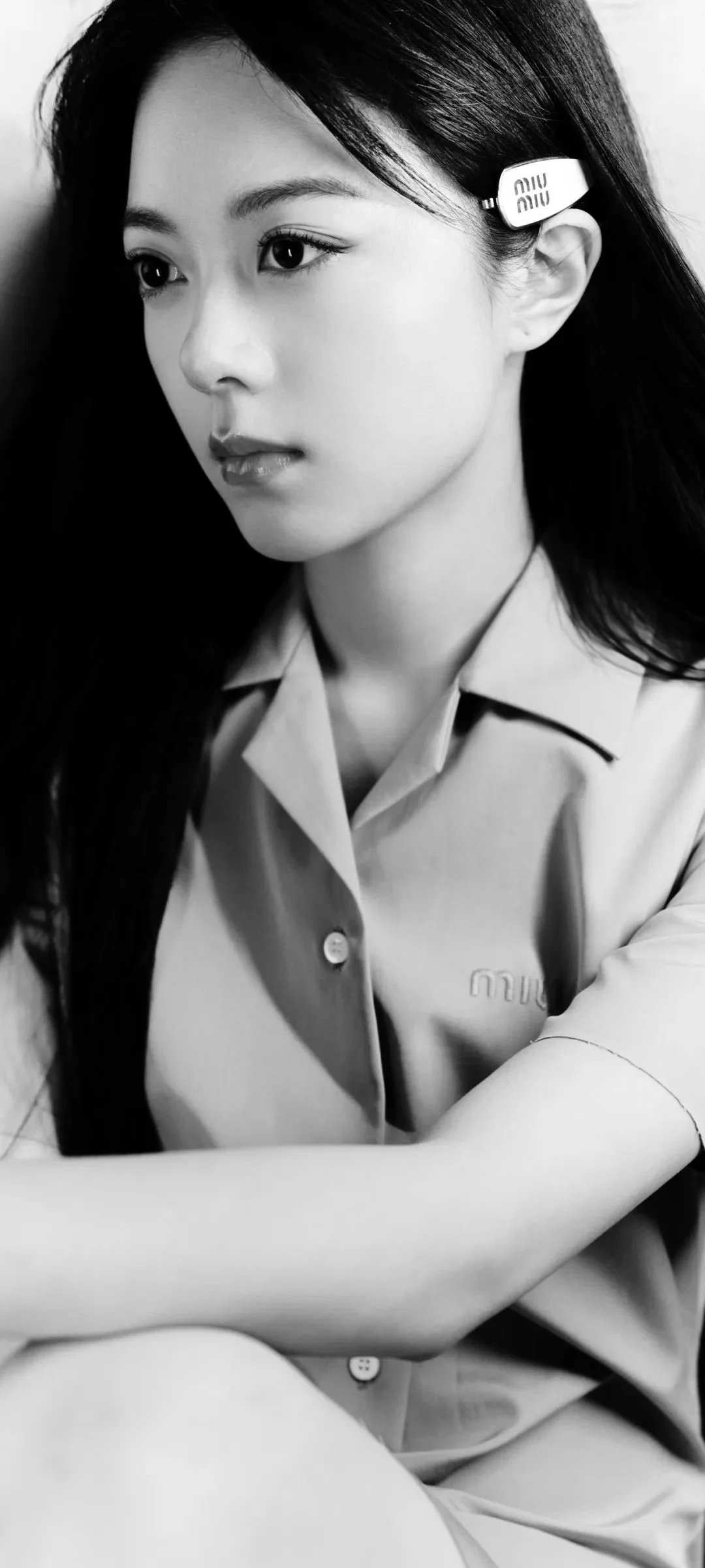 長い髪の女性が淡い色の襟付きシャツを着たモノクロのポートレートです。