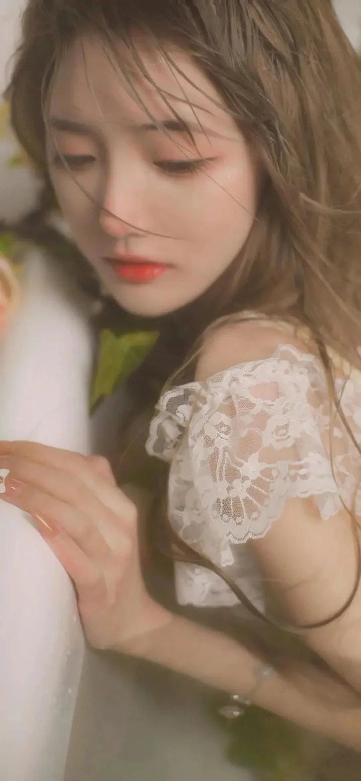 흰색 레이스 블라우스를 입은 긴 머리 여성의 부드러운 클로즈업 인물 사진입니다.