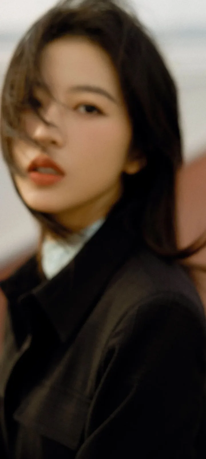 一位长发女性穿着黑色外套面对镜头。