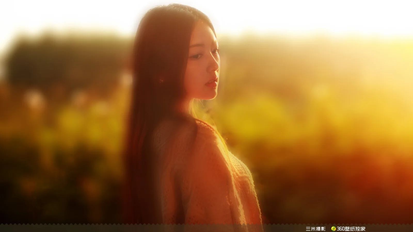 一名女子在金色夕阳和朦胧户外背景前的侧脸画面。