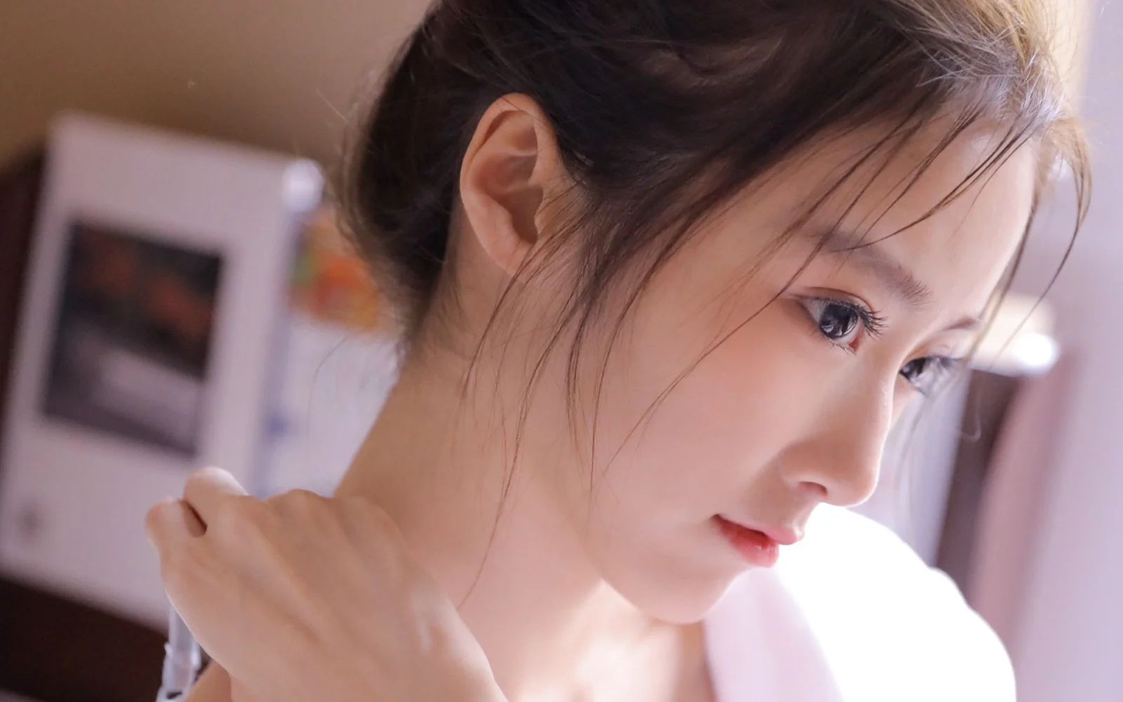 一位女性的近距离侧脸肖像沐浴在柔和光线中。