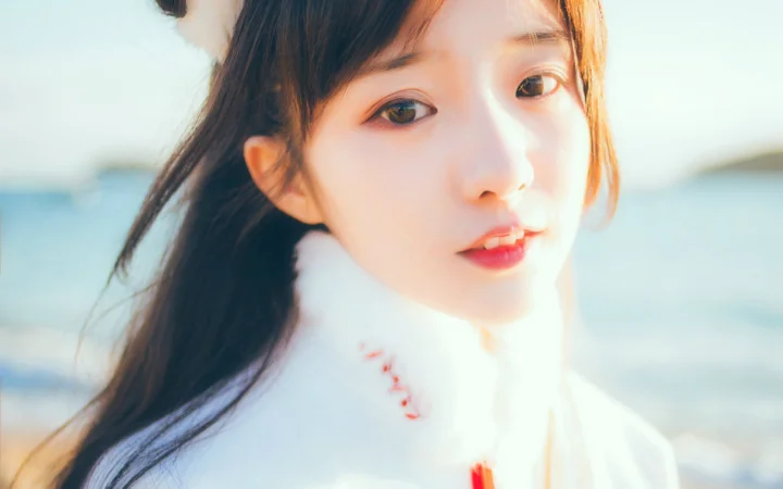 一名长发女子在海边阳光下的近距离肖像。