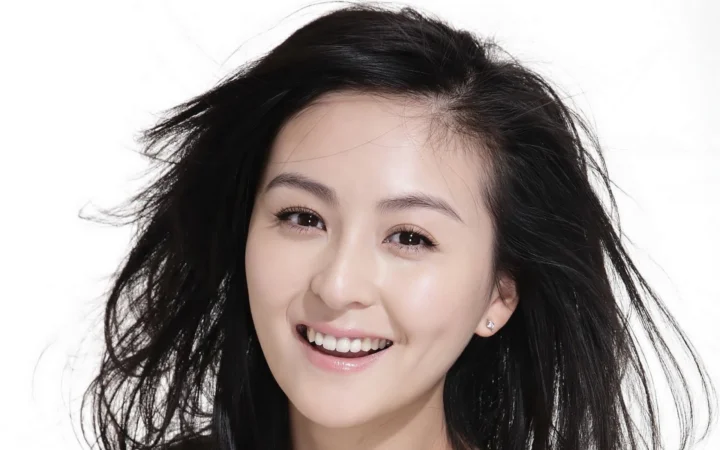 一位长着深色长发的微笑女性面向镜头，背景为白色。
