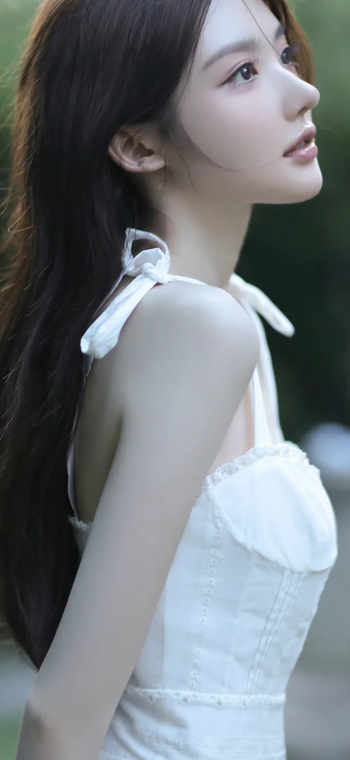 一名身穿白色连衣裙的女子以侧脸姿态面对镜头。