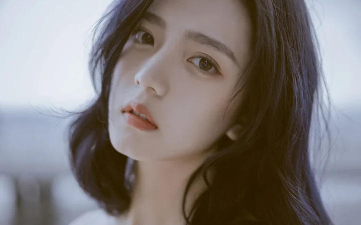 긴 머리의 성인 여성을 부드러운 차가운 색감의 빛으로 담은 클로즈업 인물 사진입니다.