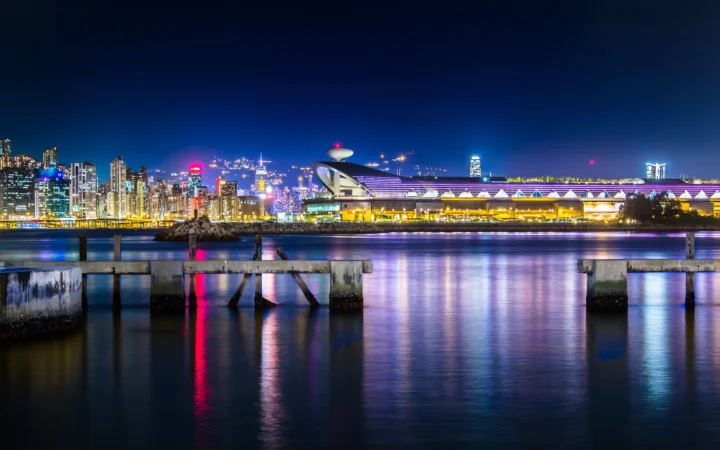 夜色中的城市天际线、滨水建筑与灯光倒映在平静水面上。