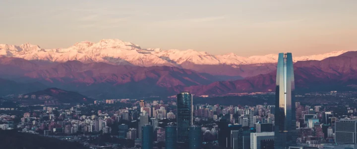 城市天际线坐落在壮丽的雪山与暮色天空之间。