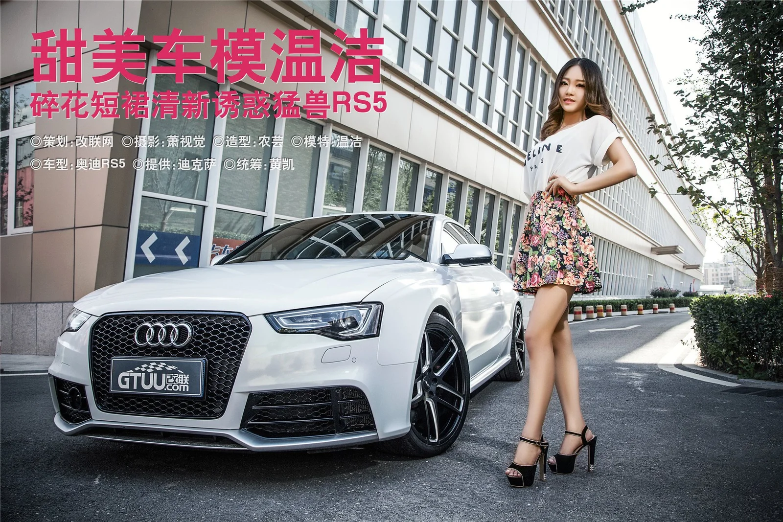 一辆白色轿车停在建筑外，一名身穿白色上衣和花卉短裙的成年女性站在车旁。