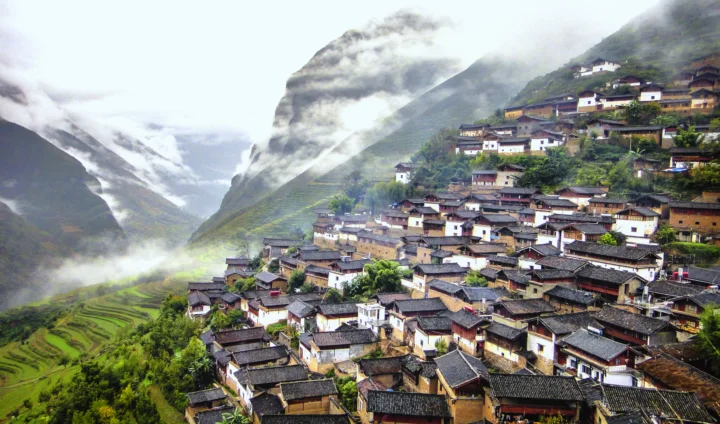 云雾缭绕的高山村落坐落在层层梯田之间。
