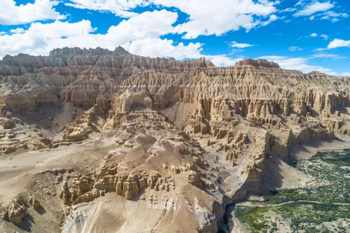蓝天白云下，层叠的土林、峡谷与荒漠山地延展开来。