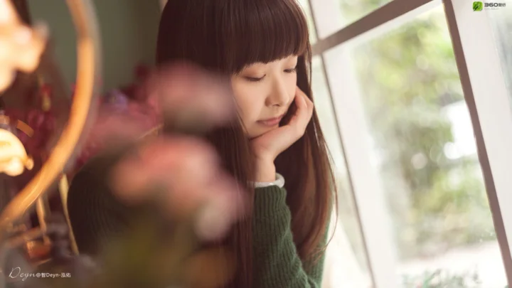 一名女子靠在窗边，柔和的室内光线映照在她的脸上。