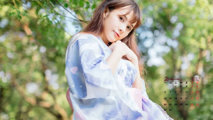 一名女子站在阳光斑驳的森林中，穿着浅色上衣并看向镜头。