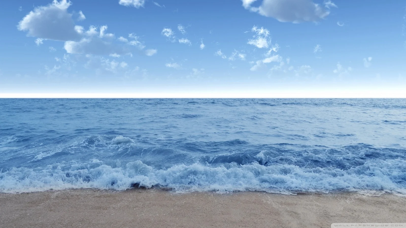 海浪拍打沙灘，遠處是開闊的藍色海面與晴朗天空。