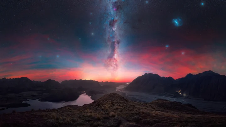绚丽的银河和繁星悬挂在群山与湖泊上空，地平线处透出红色暮光。